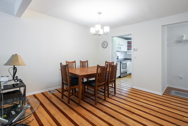 201 Greens Farm Rd Unit 201, Branford, CT 06405 - dining space with light wood-style floors, a chandelier, and baseboards