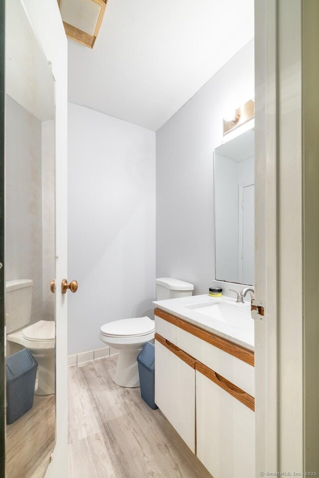 201 Greens Farm Rd Unit 201, Branford, CT 06405 - half bathroom featuring toilet, wood finished floors, and vanity