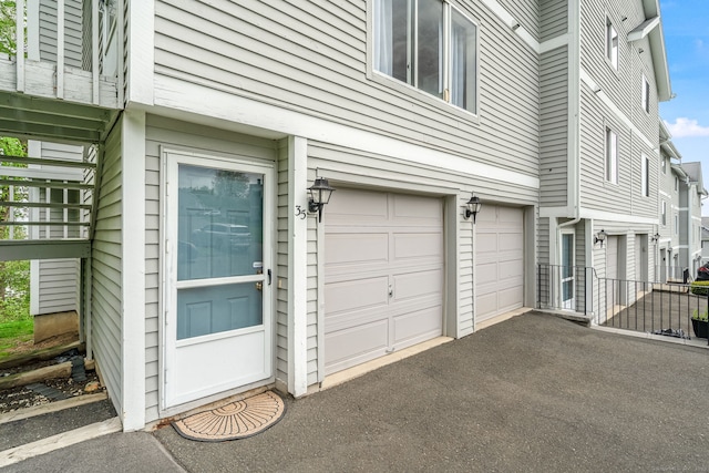 view of side of home with driveway and a garage
