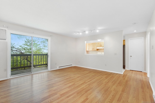 unfurnished living room with light wood-style floors, baseboards, and a baseboard heating unit