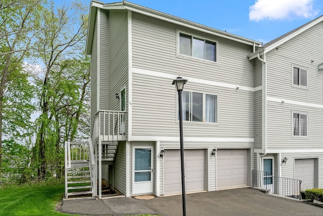 view of front facade featuring driveway, stairway, and a garage