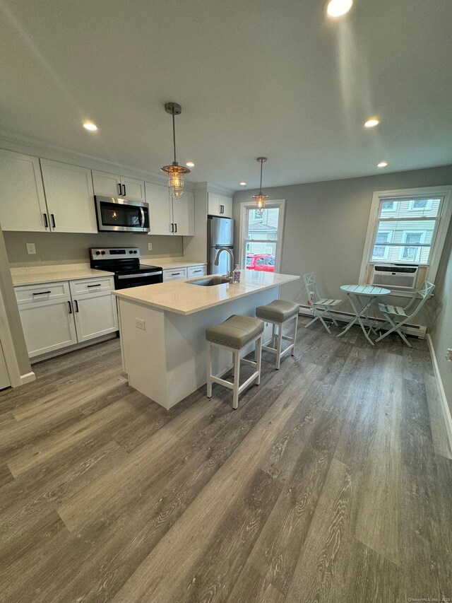 252-254 Liberty St, Meriden, CT 06450 - kitchen with appliances with stainless steel finishes, recessed lighting, dark wood-type flooring, white cabinets, and an island with sink