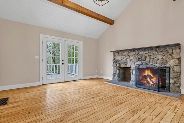 unfurnished living room with french doors, beam ceiling, hardwood / wood-style floors, a fireplace, and baseboards