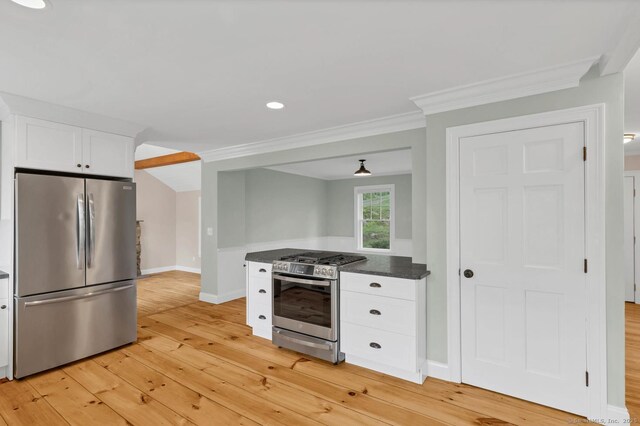 kitchen with appliances with stainless steel finishes, light wood finished floors, white cabinets, dark countertops, and baseboards