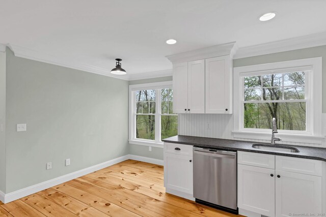 kitchen with dishwasher, a sink, baseboards, ornamental molding, and plenty of natural light