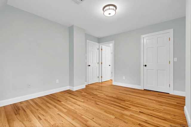 unfurnished bedroom with baseboards and light wood finished floors