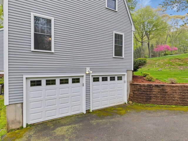 garage featuring asphalt driveway