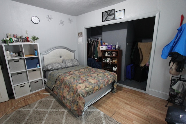 bedroom featuring wood finished floors, a closet, and a textured ceiling