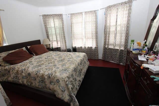 bedroom with ornamental molding and wood finished floors