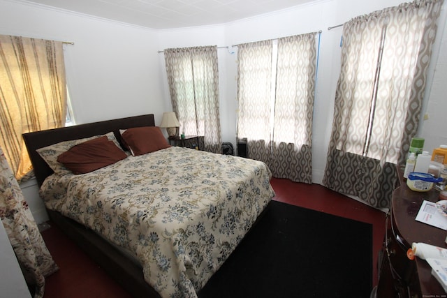 bedroom with crown molding and wood finished floors