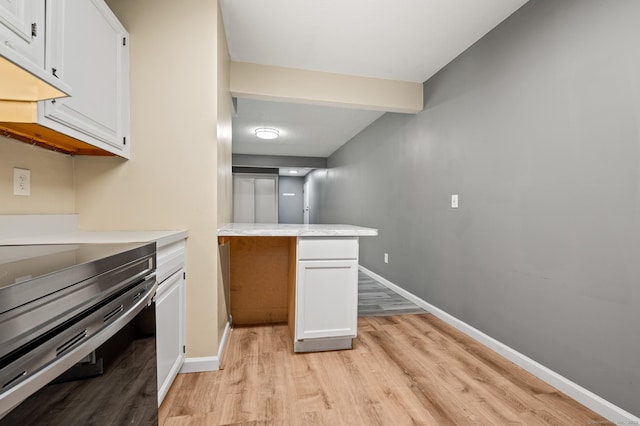 kitchen with stainless steel electric range, light wood-style flooring, white cabinets, and light countertops