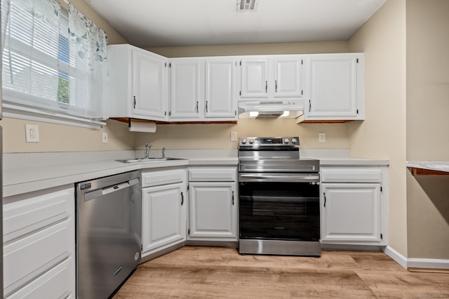 kitchen featuring appliances with stainless steel finishes, a sink, under cabinet range hood, and light countertops