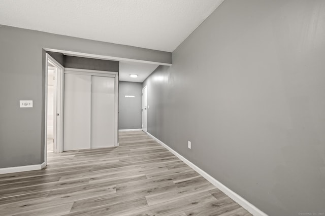 hallway with baseboards and light wood-type flooring