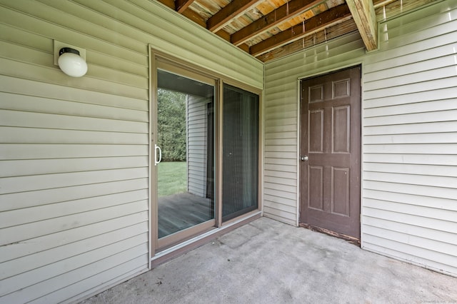 view of exterior entry with a patio