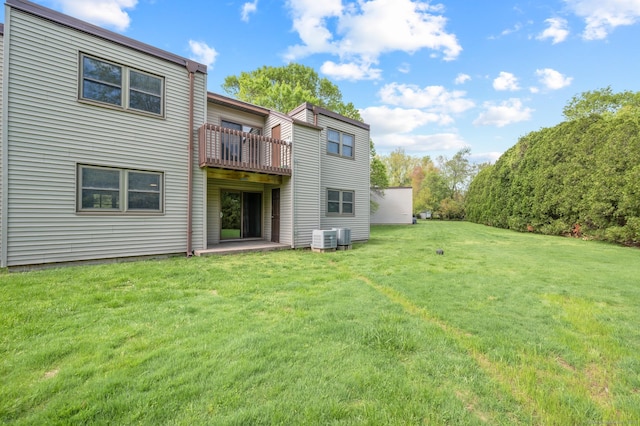 back of property featuring cooling unit and a yard