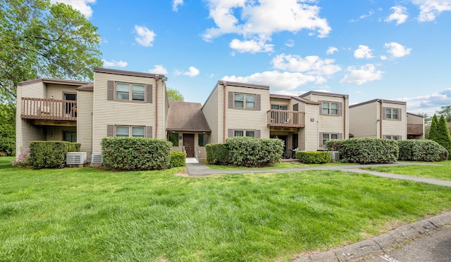 townhome / multi-family property with a front yard and a balcony