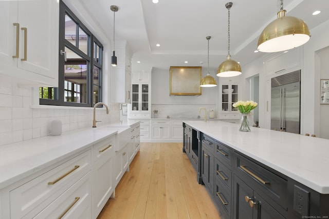 168 Proprietors Xing, New Canaan, CT 06840 - kitchen with built in fridge, white cabinets, a sink, glass insert cabinets, and tasteful backsplash