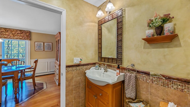 230 Ball Pond Rd, New Fairfield, CT 06812 - bathroom with tile walls, wood finished floors, vanity, baseboard heating, and wainscoting