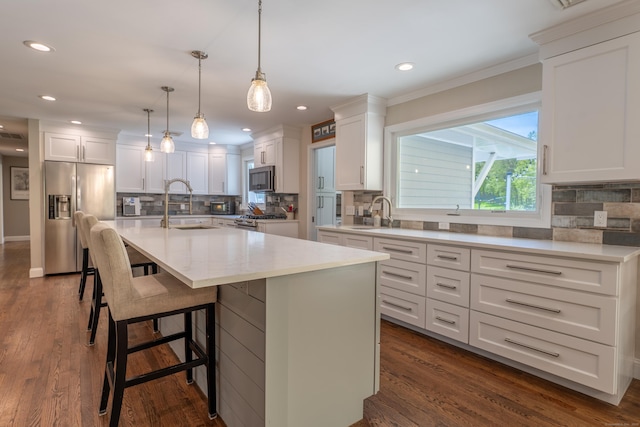 kitchen with appliances with stainless steel finishes, a sink, decorative backsplash, white cabinetry, and recessed lighting