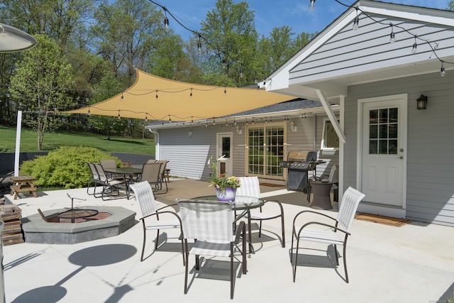 view of patio featuring a fire pit, outdoor dining area, and grilling area