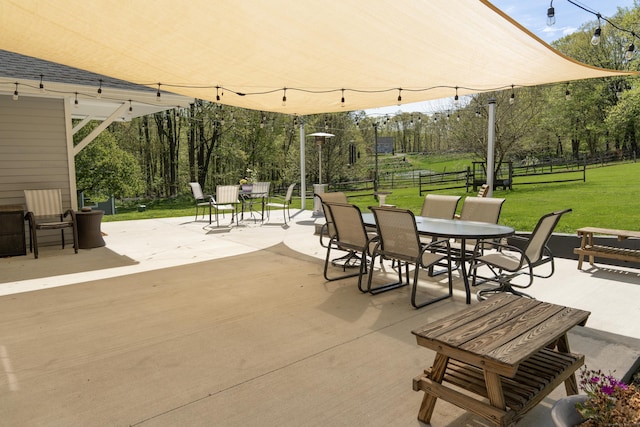 view of patio / terrace featuring outdoor dining area and view of wooded area