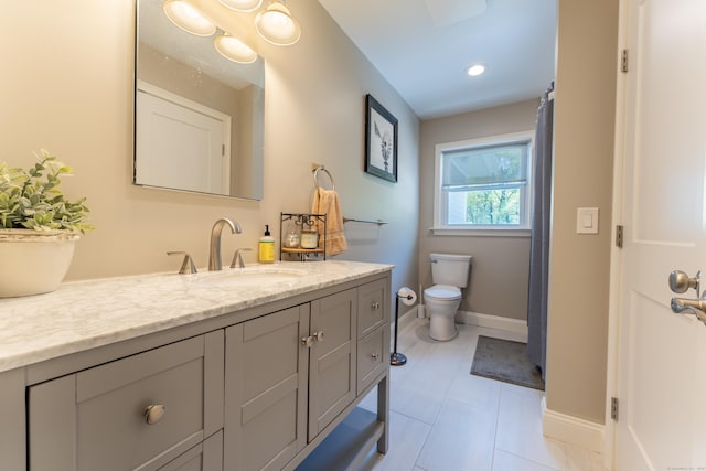 full bath with toilet, vanity, baseboards, and tile patterned floors