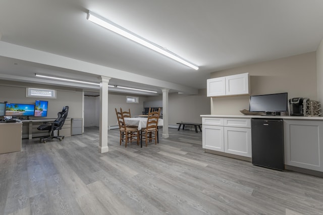 kitchen featuring white cabinetry, light wood-style flooring, refrigerator, and light countertops