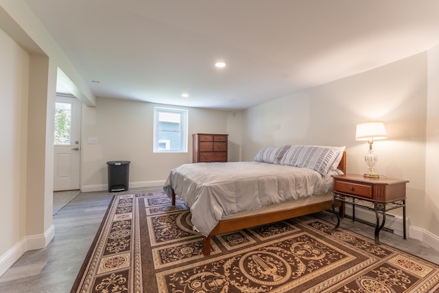 bedroom featuring multiple windows, baseboards, recessed lighting, and wood finished floors
