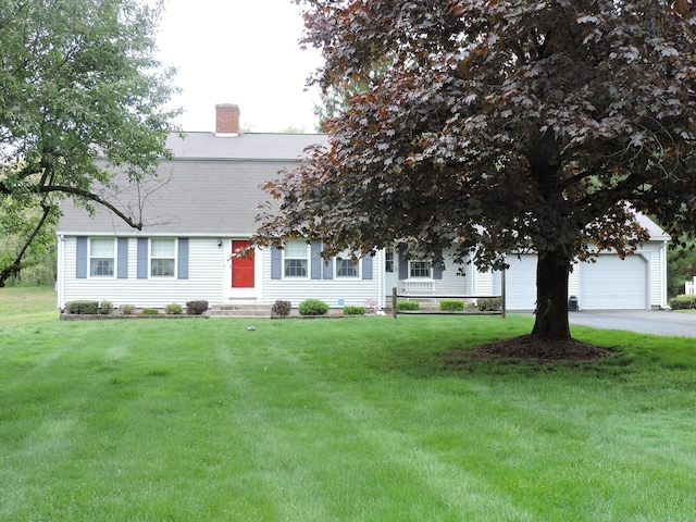 view of front facade featuring an attached garage, a chimney, and a front yard