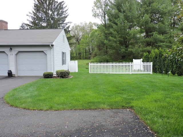 view of yard featuring fence and a garage