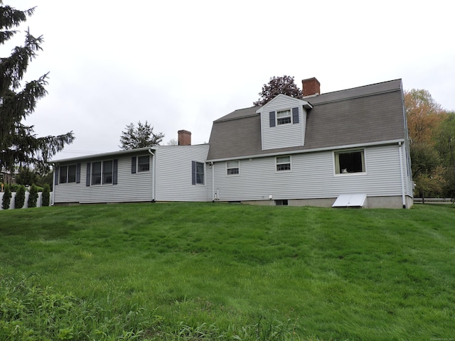 back of house with a yard and a chimney
