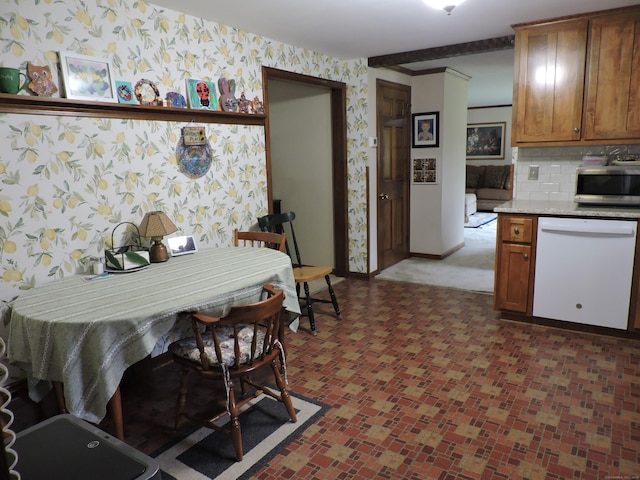 kitchen with wallpapered walls, dishwasher, baseboards, stainless steel microwave, and light countertops