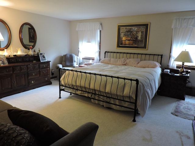 bedroom with light carpet and multiple windows