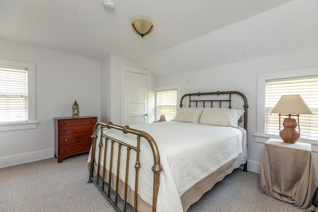 bedroom featuring light colored carpet, baseboards, vaulted ceiling, and multiple windows