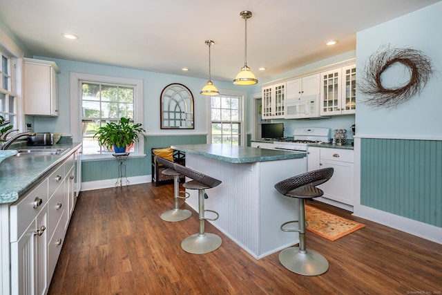kitchen featuring a sink, white appliances, dark wood-style flooring, white cabinets, and plenty of natural light