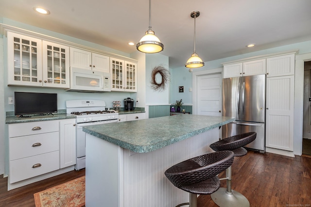 kitchen featuring white appliances, dark wood-type flooring, glass insert cabinets, a kitchen island, and recessed lighting