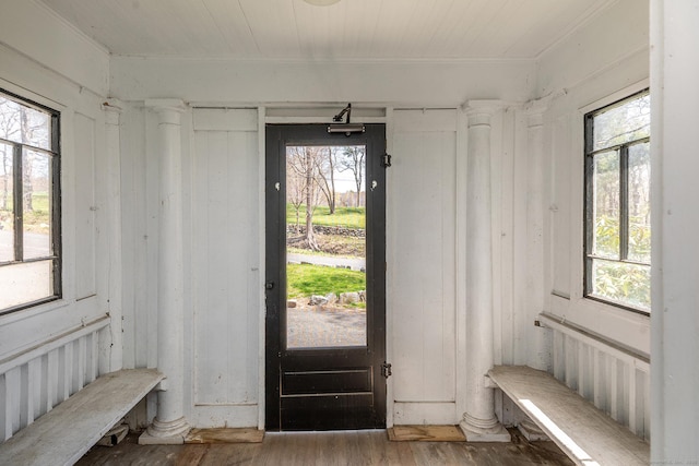 mudroom with healthy amount of natural light, wood finished floors, and crown molding