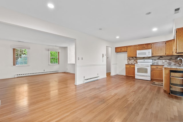 kitchen with white appliances, a baseboard radiator, open floor plan, light wood-style flooring, and recessed lighting