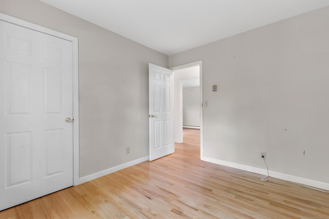 unfurnished bedroom with light wood-style flooring and baseboards
