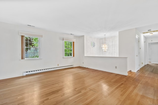 unfurnished living room featuring baseboard heating, light wood-style flooring, baseboards, and a chandelier