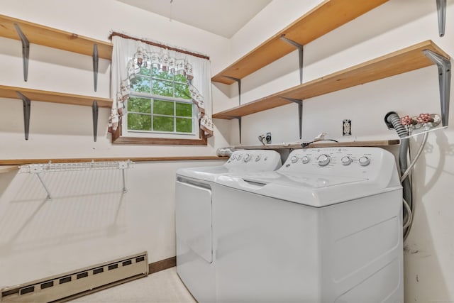 clothes washing area with baseboard heating and washer and dryer