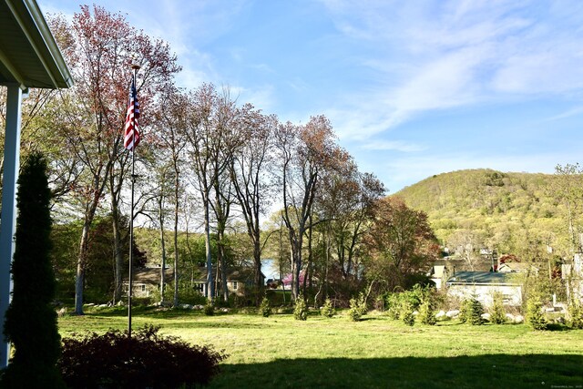 view of green lawn with a mountain view