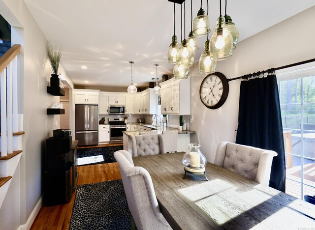 dining area with dark wood-type flooring, baseboards, and recessed lighting