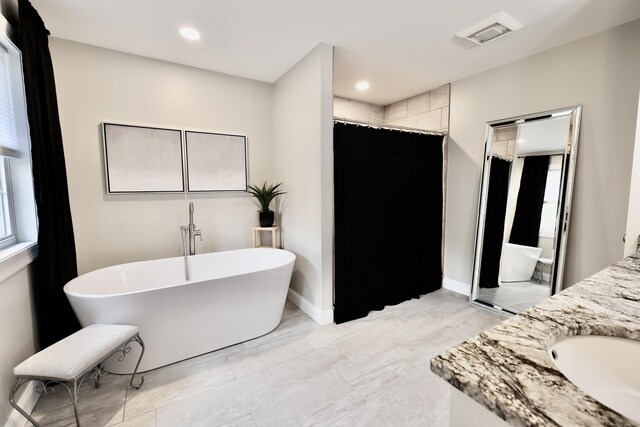 full bathroom with a shower with shower curtain, a freestanding bath, marble look tile flooring, vanity, and recessed lighting