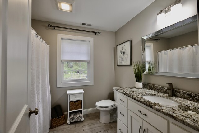 bathroom with toilet, vanity, and baseboards
