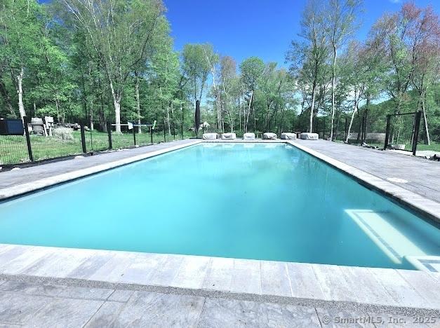 swimming pool featuring view of scattered trees