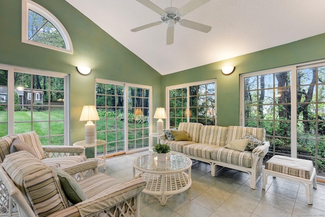 sunroom with high vaulted ceiling, ceiling fan, outdoor lounge area, and tile patterned flooring