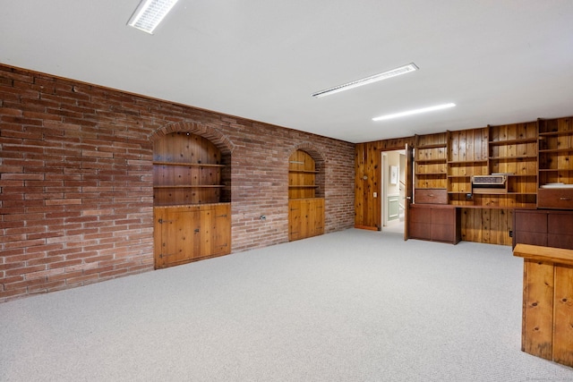 unfurnished office featuring carpet floors and brick wall