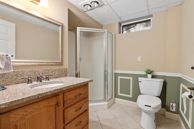 bathroom featuring a shower stall, tile patterned floors, toilet, vanity, and baseboards