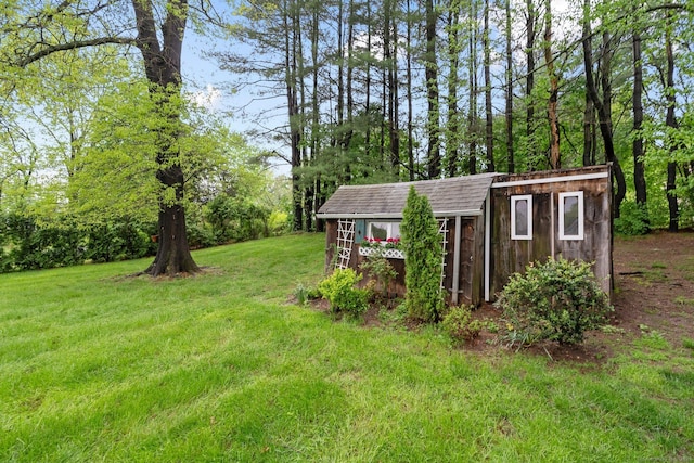 view of green lawn featuring an outbuilding and a shed